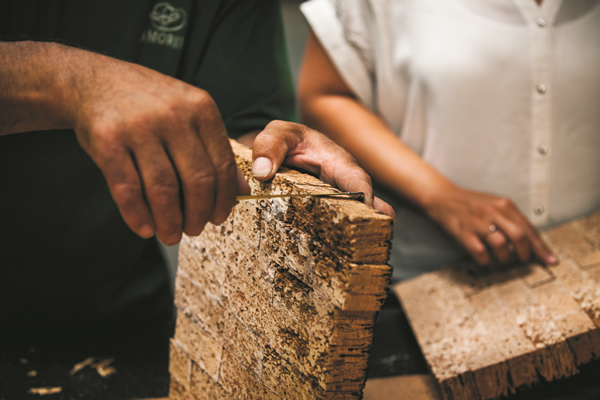 someone's hands working with a piece of cork bark wood