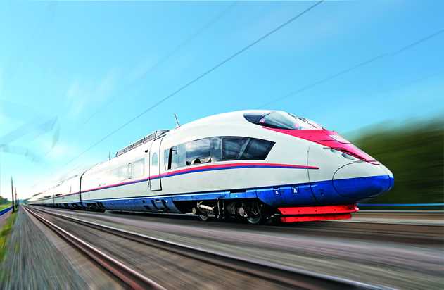 a red, white and blue train speeding along the tracks